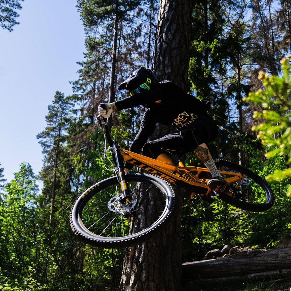 homem numa bicicleta MTB numa floresta usando amortecedores Ohlins